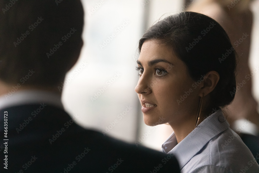 Wall mural close up head shot concentrated millennial indian woman manager employee talking to male confident c