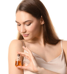 Fototapeta premium Beautiful woman holding bottle with natural essential oil on white background, closeup