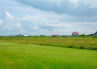 Fototapeta na wymiar Grassy cloudy farm landscape in rural Iceland