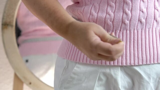 fat woman in pink sweater measures waist circumference with centimeter tape, belly stands, concept time to lose weight, wrong lifestyle, consequences of inactivity, unhealthy diet