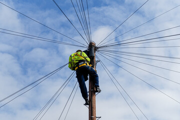 Telecommunications, telecom engineer at work on the top of a telegraph pole - obrazy, fototapety, plakaty