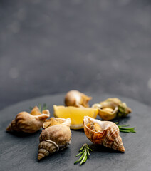 Snails with lemon on black platter