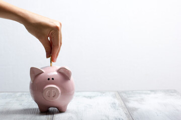 woman hand putting money coin into piggy for saving money wealth and financial concept - 466353922