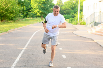 Male runner checking pulse outdoors