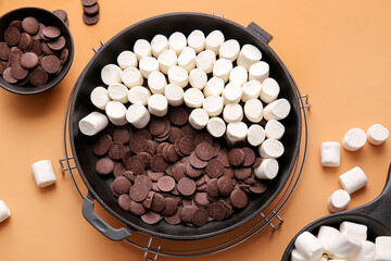Frying pan with uncooked S'mores dip on color background