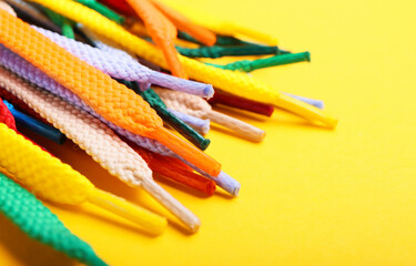 Many shoe laces on yellow background, closeup