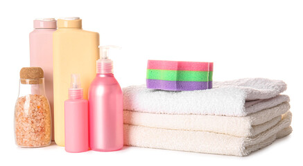 Bottles of cosmetic products, bath sponge and stack of clean towels on white background