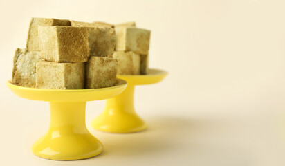 Stands with tasty hojicha marshmallows on color background, closeup