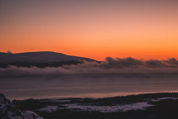 Dawn on a mountain under the clouds in the north in winter 