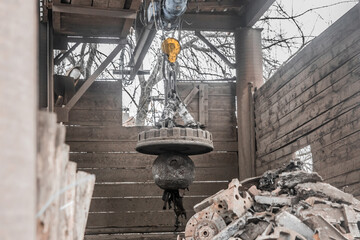 Magnetic scrap crane recycles and unloads junk and old metal in a landfill