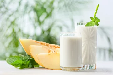 Rolgordijnen Glasses of tasty melon milkshake on table © Pixel-Shot