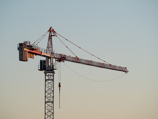 Construction crane on a construction site used for the construction of residential houses - obrazy, fototapety, plakaty