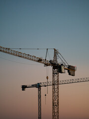 Fototapeta premium Construction crane on a construction site used for the construction of residential houses