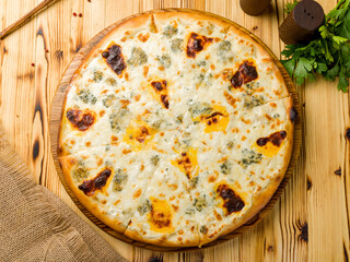 Pizza Quattro formaggi on wooden table top view