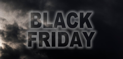 "Black Friday is coming" concept. Big black friday neon sign glowing over dark clouds in the background.