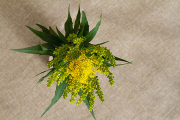 Top down view of yellow goldenrod bouquet; Goldenrod bouquet on a beige table cloth
