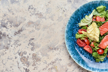 Fresh salad with salmon and vegetables on color background
