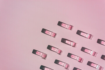 Layout with pink transparent plastic cubes and sharp shadows of sun at the pink background. Flat lay. Copy space.