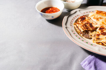 Typical mexican fast food beef quesadillas with hot chilli sauce on gray - purple background. Photo with copy space.