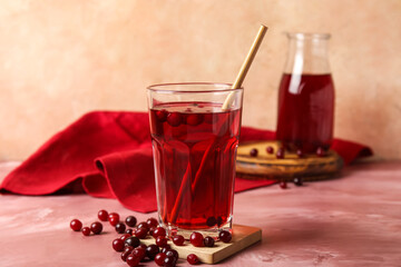 Glass with healthy cranberry juice on color background
