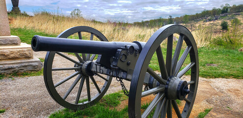 old cannon stands on the grass in the places of former battles