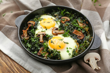 Frying pan with tasty Shakshouka on wooden background