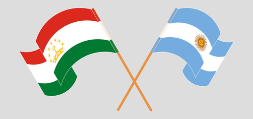 Crossed and waving flags of Tajikistan and Argentina