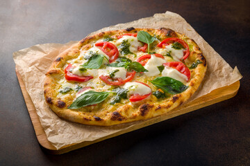 Italian pizza Margherita buffalo with tomatoes, mozzarella and basil on brown concrete table, pinsa
