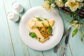 omelet with mushrooms, spinach and cheese top view on mint wooden table