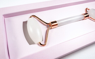 White massage quartz roller for the face close-up isolated on a white background. Beauty and care...