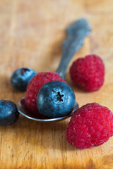 Still life with fresh raspberries and blueberries on the wooden table
