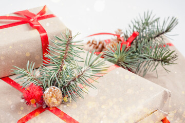 Handmade gift boxes with red ribbon and Christmas tree on white background. Christmas greeting card, side view. Winter Xmas holiday concept.
