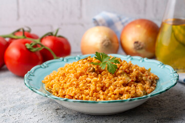 Traditional turkish bulgur pilaf with tomato sause in plate (Turkish name; meyhane pilavi)