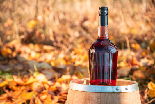 Bottle of alcohol drink with yellow leaves in the background.