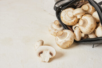 black bag and mushrooms on beige background copy space