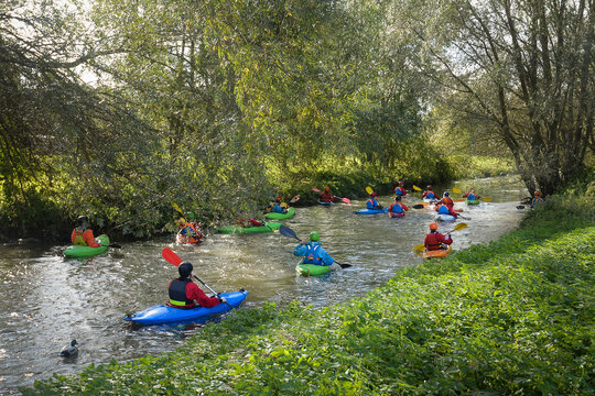 Group of people canoeing in peaceful Stour river in Kent England.