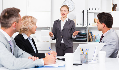 Fototapeta premium Confident businesswoman explaining to workgroup business plans in office