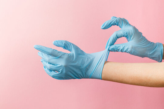 female hands wear blue medical surgical gloves on pink background. Safety at pandemic, quarantine. Measures against infection. Stay safe. Stop virus. Prevention Remedies. Woman doctor