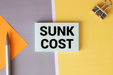 Obraz premium White paper card with text SUNK COST sheet of white paper for notes.