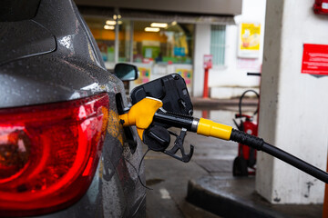 Pumping gasoline fuel in car at gas station. Refueling automobile with gasoline or diesel with a...