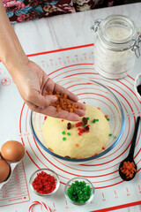 A Female Chef Sprinkles Dried Fruit on Raw  Dough of Stollen Christmas Bread