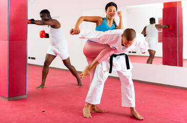 Fototapeta na wymiar Asian female is fighting with trainer on the self-defense course for woman in sport club