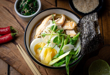 ramen soup with chicken, noodles, herbs and egg