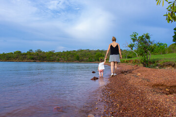Mãe e filha - obrigado mãe - agradecimento à mãe - dia das mães - mãe ensinando filha a caminhar na praia de lago - ensinamento de mãe