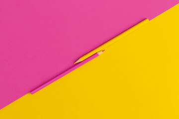 Colored pencils on yellow, pink background. Top view with copy space. Flat lay. Back to school concept.