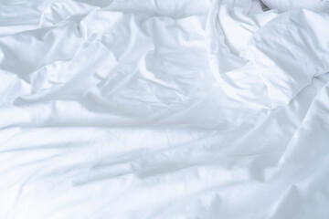 Obraz premium Close up messy Soft pillows on comfortable crumpled linen bed sheet in the hotel. Concept bed after sex night of new married couple or long relaxing weekend.