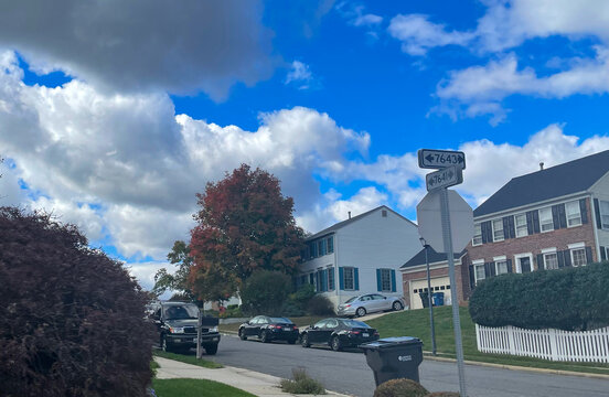 Lorton, Virginia, USA - October 31, 2021: Suburban Homes Surrounded by Trees Changing Colors and Leaves Falling from the Branches on a Bright Autumn Morning