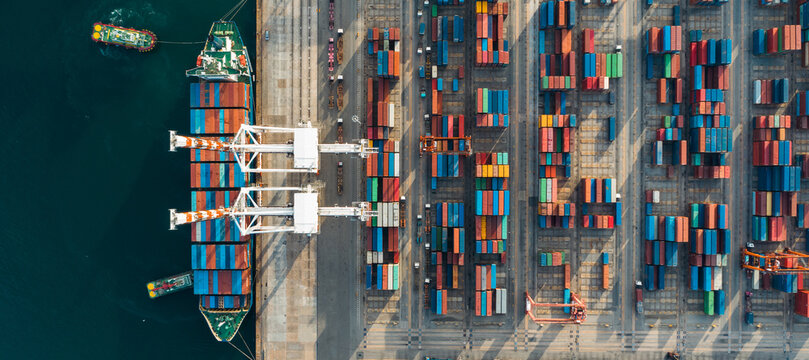 Fototapeta Aerial view. Container ship in pier with crane bridge carries out export and import business in the open sea. Logistics and transportation  
