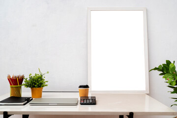 Blank picture frame on wooden table with books