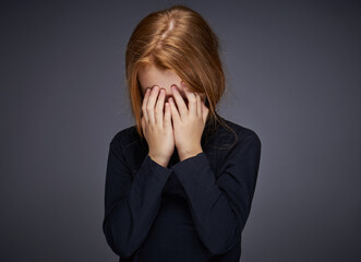 red-haired girl with freckles on her face in a black sweater posing